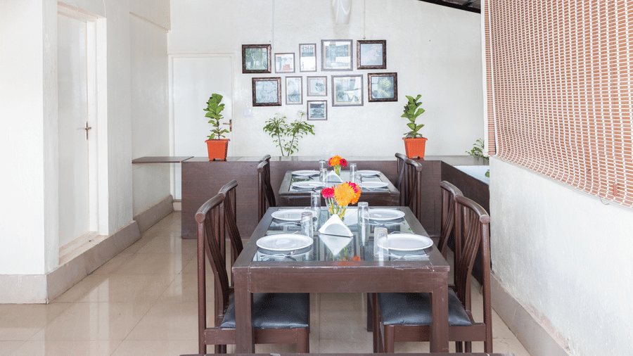 Spacious in-house restaurant with wooden dining tables at Sanctum Suites Domlur Bangalore
