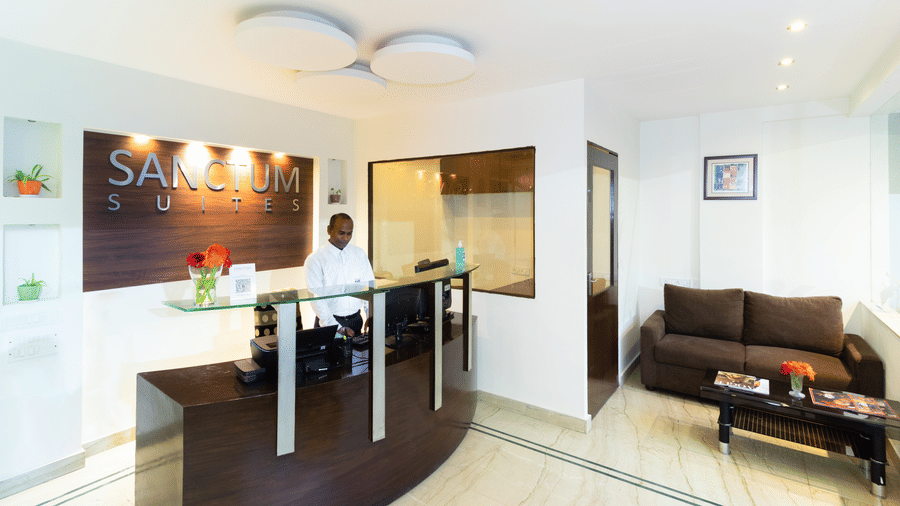 Studio room with kitchenette, sofa and dining area at Sanctum Suites Domlur Bangalore