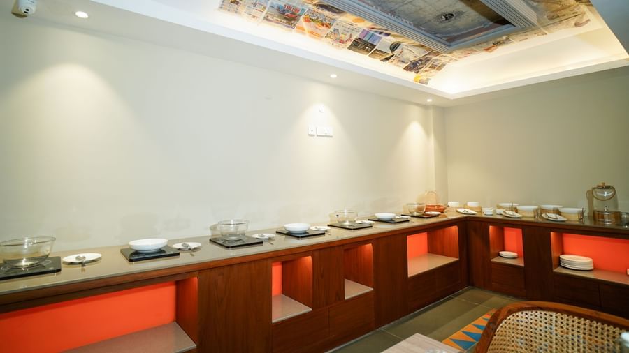 A buffet counter with food warmers and serving dishes in a well-lit room | Sukama Resort & Spa, Nainital