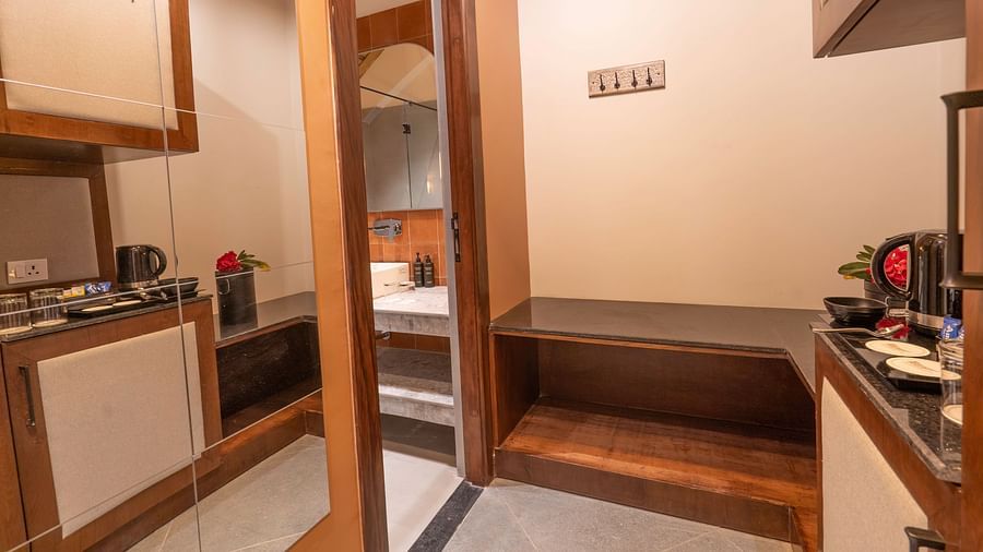 Compact kitchenette area with cupboards and appliances at The Chamomile Estate.