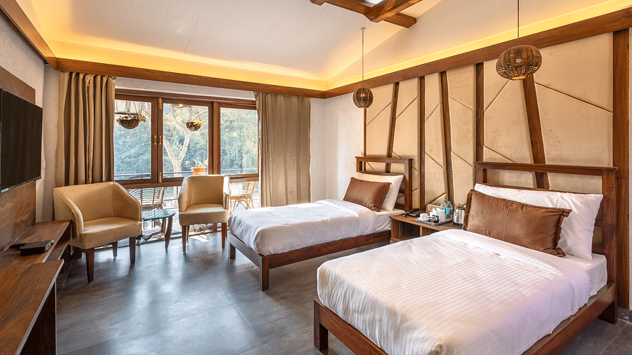 Twin beds facing the TV of River View Room at the Sylvan Retreat, Dehradun. 
