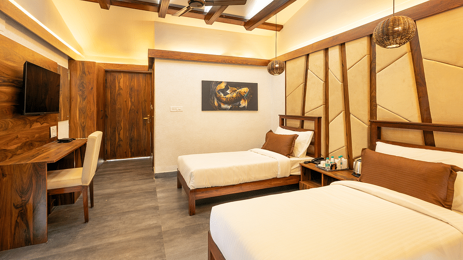 Twin beds facing the TV of River View Room at the Sylvan Retreat, Dehradun. 
