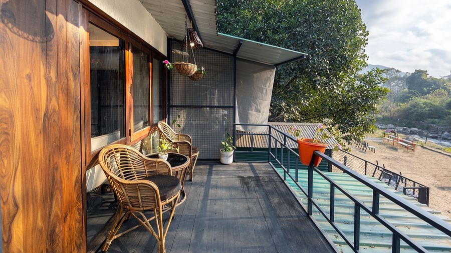The balcony with chairs facing the view of River View Room at the Sylvan Retreat, Dehradun.