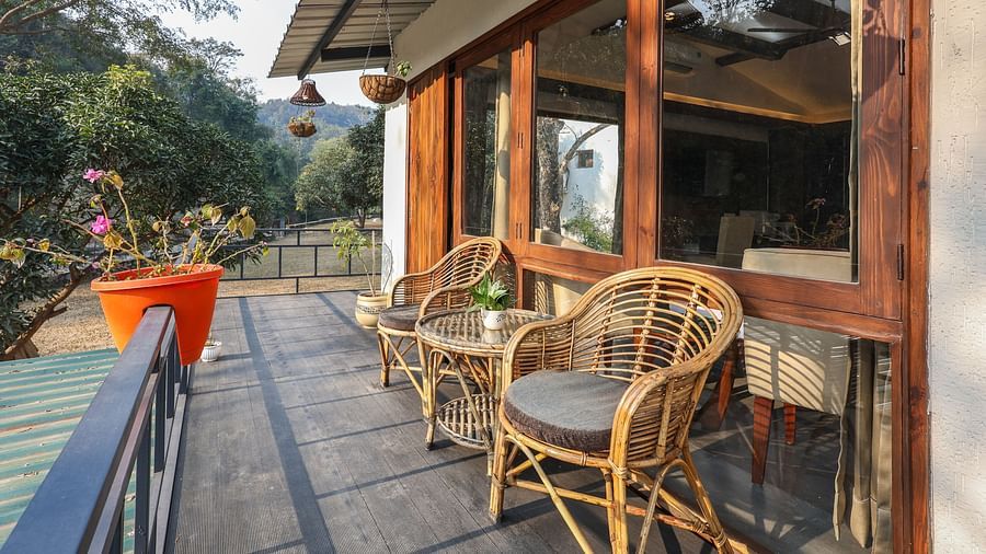 The balcony with chairs facing the view of River View Room at the Sylvan Retreat, Dehradun.