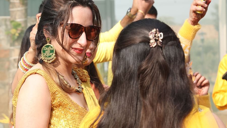 Guests in yellow attire smiling and enjoying the event at Tisya Farms, Gurgaon.