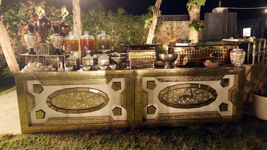 Buffet counter at night at Tisya Farms, Gurgaon with food items, decorated counters, and overhead lighting.