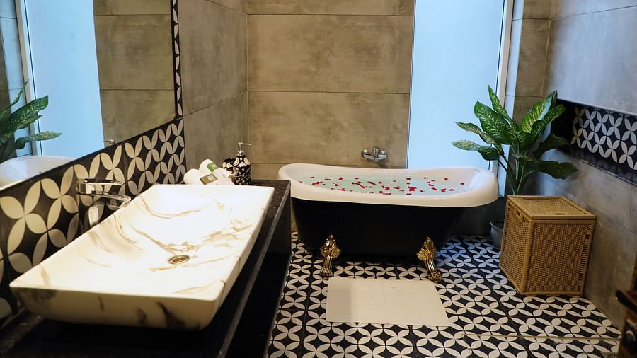 A modern bathroom featuring a sleek wash basin and a luxurious bathtub at Tisya Farms, Gurgaon.