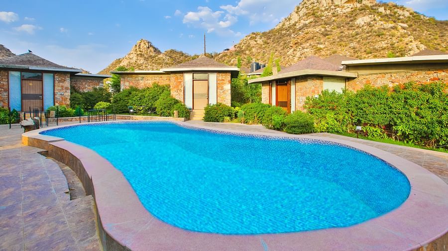 A swimming pool with accommodations in the background at Valley by Grassfield.
