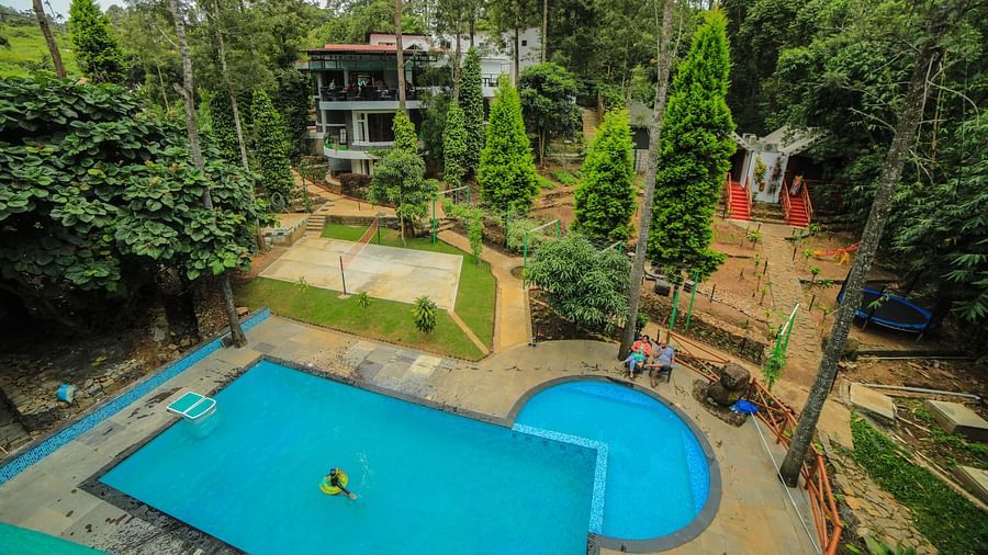 Aerial view of a swimming pool with tress surrounding it at WOW Bison Woods.