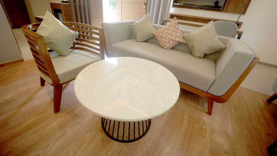Cosy lounge corner with cushioned chairs, a circular centre table, and a TV console at Wyndham Garden.
