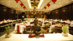A dining space at Pride Plaza Hotel, New Delhi, with several chairs and tables arranged for dining.