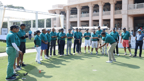 Participants and organisers gathered near the clubhouse at an exclusive golf event.