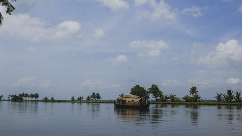 Houseboat journey on the tranquil waters of Kabini Backwaters, surrounded by lush greenery and the sights and sounds of nature