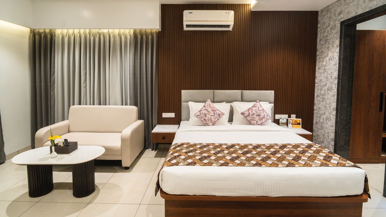 An image of a bedroom with a large bed, a sofa and a coffee table - MGM Whispering Meadows