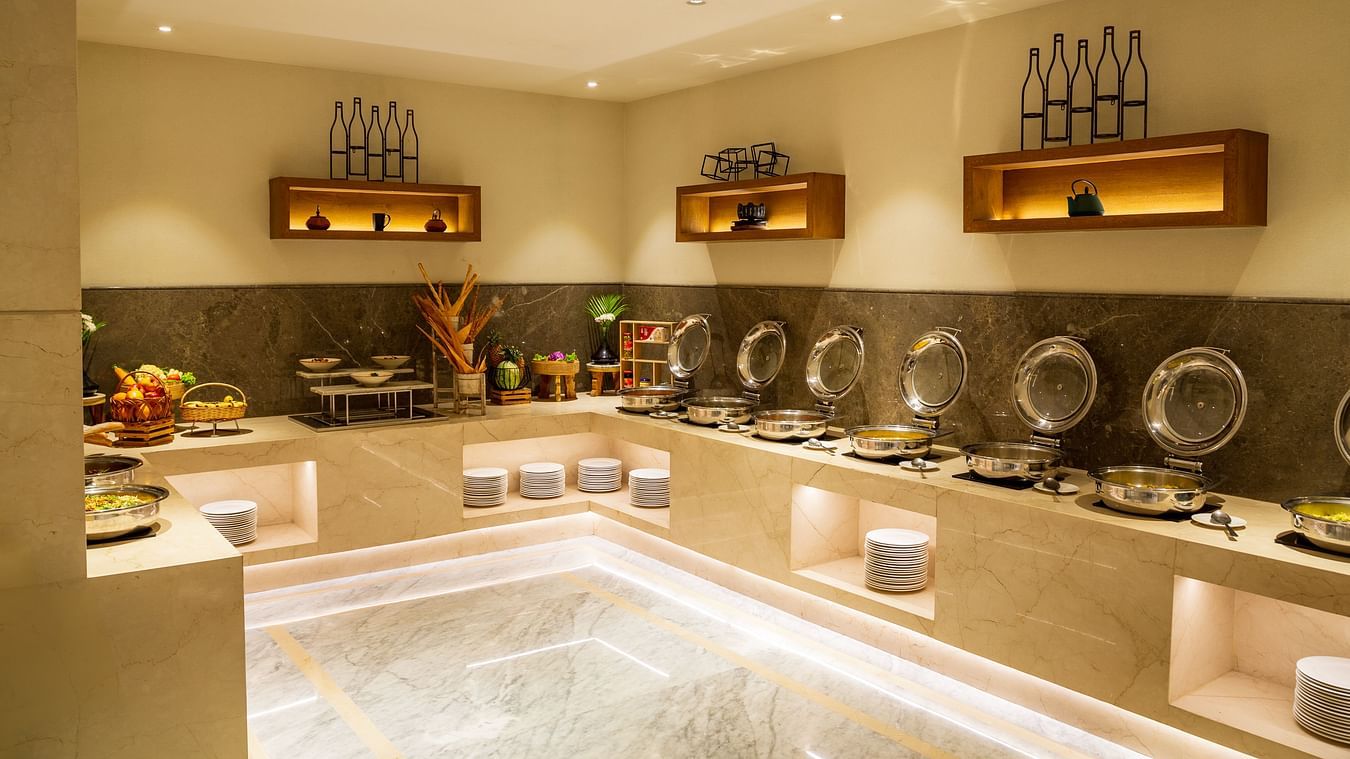 Buffet counter with a stylish interior design and elegant lighting at The Residency Towers Puducherry