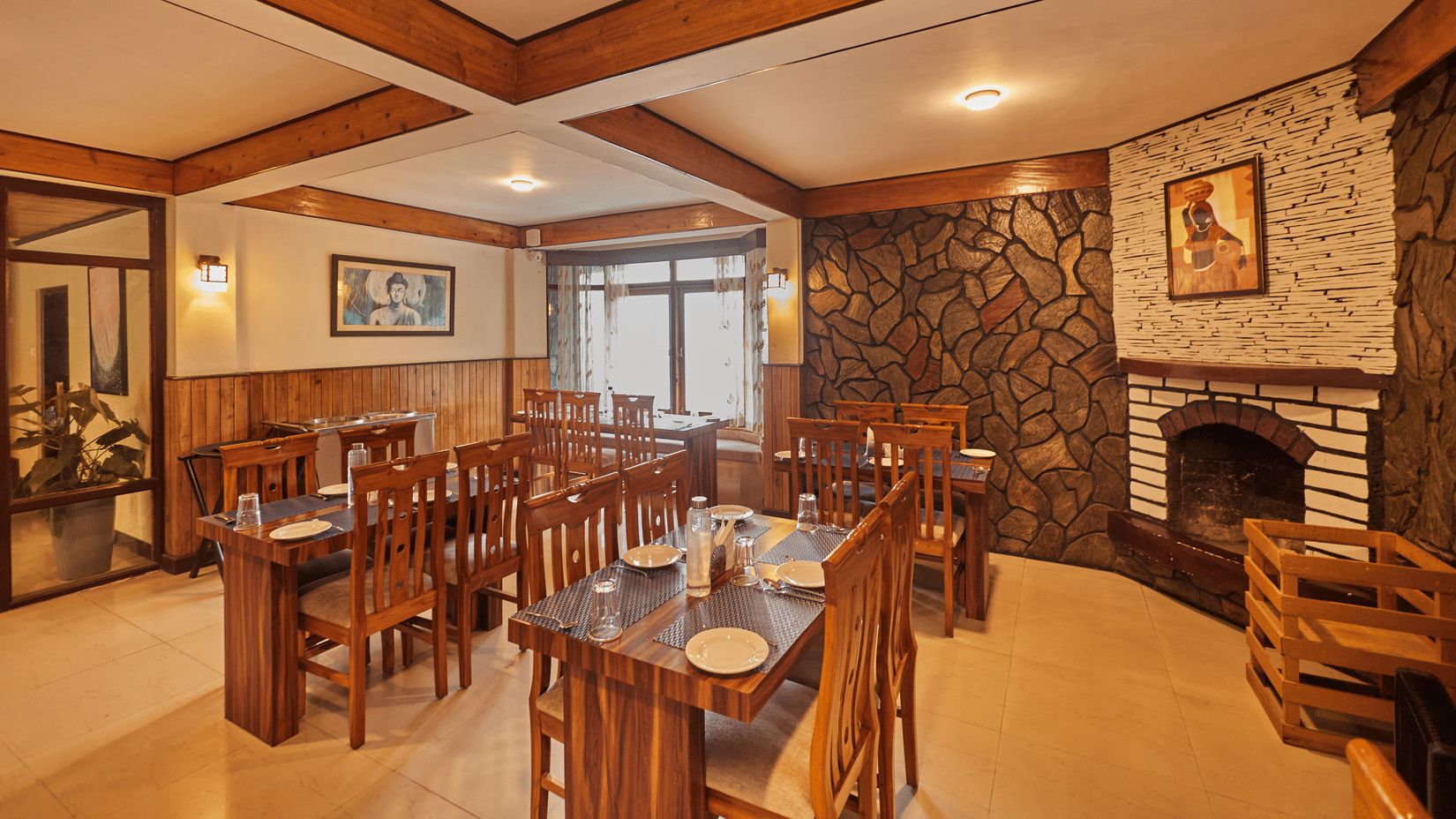 A dining room with wooden tables, fireplace, and beamed ceilings | Voyage Rodhi Resort