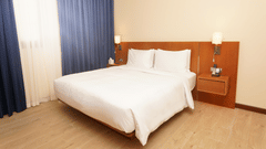 a double bed with side tables and lamps inside Classic Apartment - La Maison Hotel, Doha