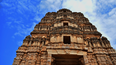 A stunning low-angle shot of a temple with intricate architecture set against the backdrop of a cloudy sky - Hotel near Tirupati temple