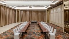 A u-shape arrangement in a cosy banquet hall with high ceilings, ambient lighting and carpeted floors - Sarovar Portico, Ajmer
