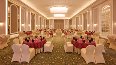 Banquet hall with round tables, chairs, and ceiling lights at Sarovar Premiere Amritsar.