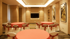 A conference hall in Zirakpur with the chairs turned towards a wall with a mounted television - Tulip Inn, Zirakpur