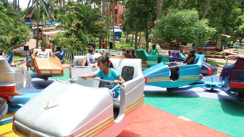 An overview of the Break Dance ride with individuals sitting in their seats - Black Thunder, Coimbatore