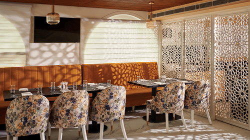 An image of our restaurant with colourful patterned chairs - Deventure Sarovar Portico, Patel Nagar