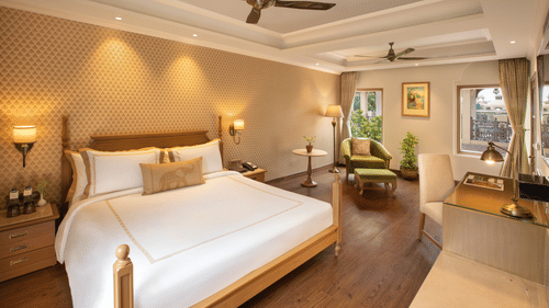 suite in manesar with a comfy king size bed, lavish interiors and wooden flooring at heritage village resort and spa