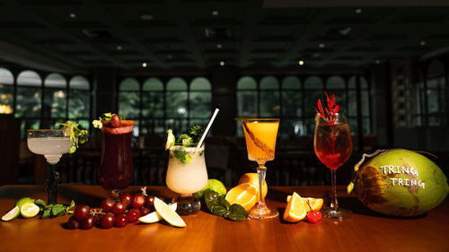A variety of colourful cocktails arranged on a table at Hotel Polo Towers, including a mojito, a piña colada, and a red wine.