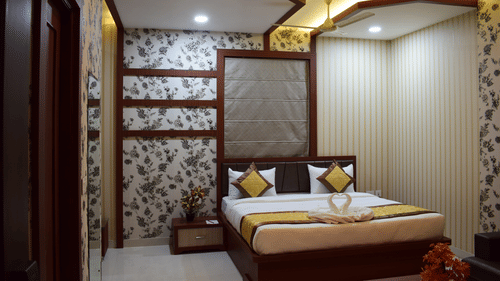 A modern luxury hotel bedroom in Varanasi, showcasing elegant decor, ambient lighting, and comfortable furnishings available through exclusive Varanasi hotel deals - Hotel Uday Palace.