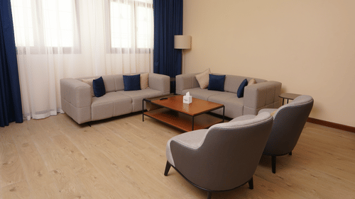 Seating arrangements inside the living room of Deluxe Apartment - La Maison Hotel, Doha - Hotel Apartments Doha Long Term