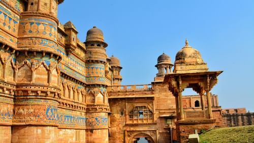 A magnificent fortress gate with colourful tile work is framed against a clear blue sky - Gwalior Sightseeing places