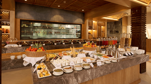 Buffet counter with decorative ceiling and well-lit serving stations - Royal Tulip, Chitwan