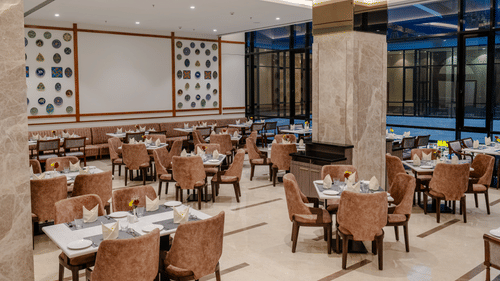 A bright and inviting dining space in Ajmer featuring cosy seating arrangements and a well-lit atmosphere to enjoy meals - Sarovar Portico, Ajmer