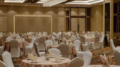 A cluster style seating arrangement in a banquet hall with cosy lighting - Sarovar Portico, Ajmer