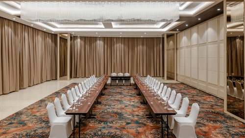 A u-shape arrangement in a cosy banquet hall with high ceilings, ambient lighting and carpeted floors - Sarovar Portico, Ajmer