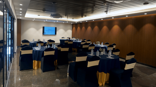 tables arranged in a cluster seating arrangement inside Conclave, the boardroom at Sarovar Portico, Kolkata Rajarhat