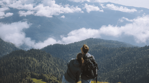 A couple enjoying the breath taking view of the mountains