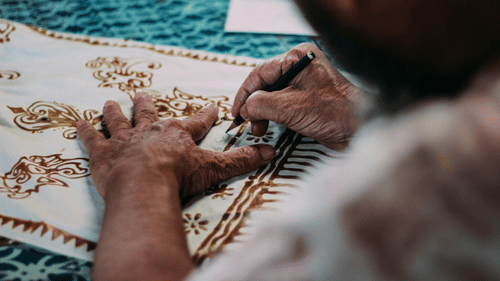 A close up shot of person making patterns on a piece of cloth