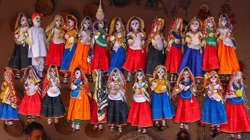 Colourful traditional Rajasthani puppets hanging on display.