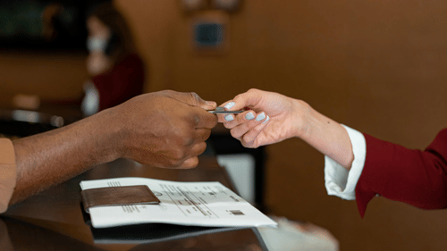 A close up shot of a man giving the room card to the receptionist