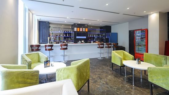 Front view of black velvet bar counter area with seating at Icon Premier Hotel by Bhagini, Devarabisanahalli
