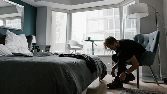 Picture of a man  wearing the shoes while resting on a chair