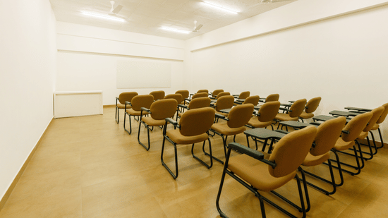 Rows of brown cushioned chairs with writing desks arranged in classroom at The Residences at CSE