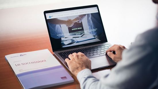 a man using a laptop for business purpose with a file next to him