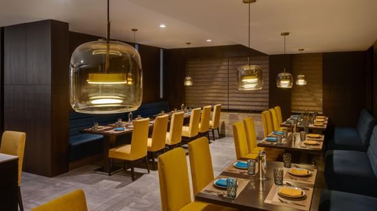 Lounge at Voyage Milestone Hotel and Banquet featuring blue sofas and a decorative wall design.