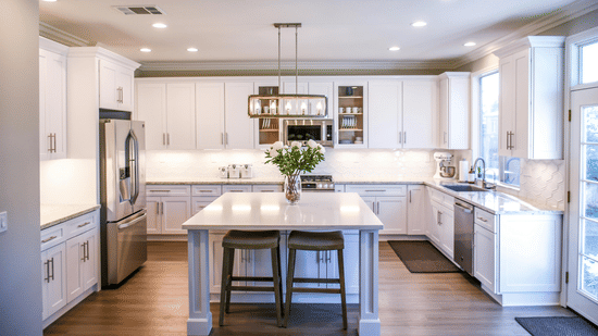 A full kitchenette view featuring a kitchen counter with bar stools and overhead lights.