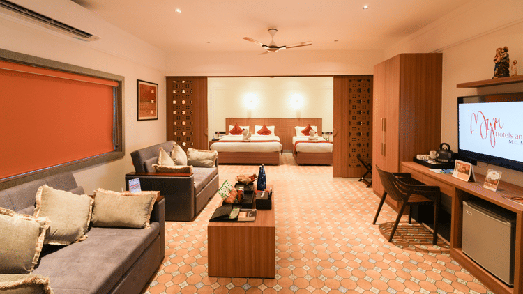 Image featuring partition between the living room and bedroom featuring sofa-cum-beds with coffee table in living room facing the TV and a double bed and a single bed in the bedroom