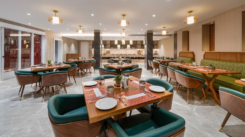 Dining area featuring plush seating, wooden tables, and warm lighting - Clarks Inn, Indore