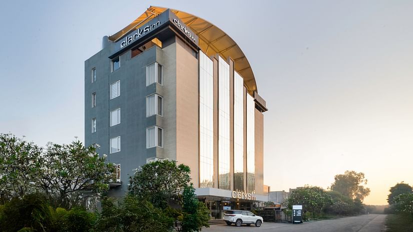 Exterior view of a Clarks Inn hotel, showcasing its modern architecture and surrounding landscape.